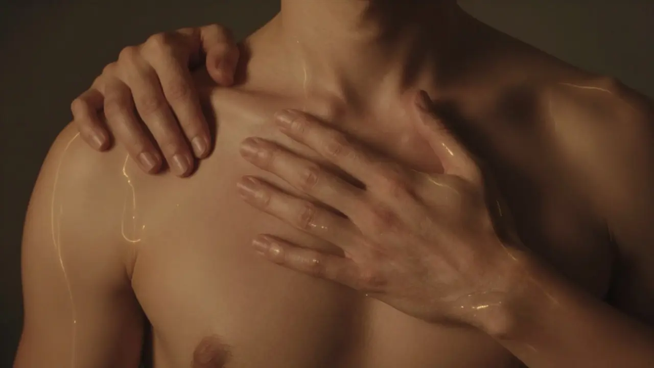 Hands hovering over a shoulder with soft golden energy flowing through the body.